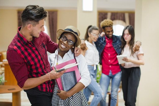 Encantadora niña negra abrazando con el estudiante