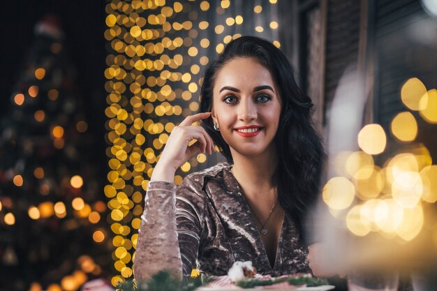 La encantadora niña sentada cerca de la mesa