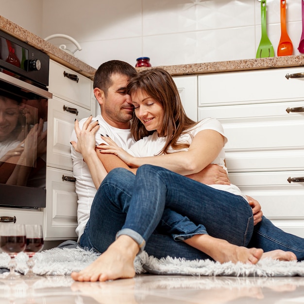 Encantadora pareja abrazándose en la cocina