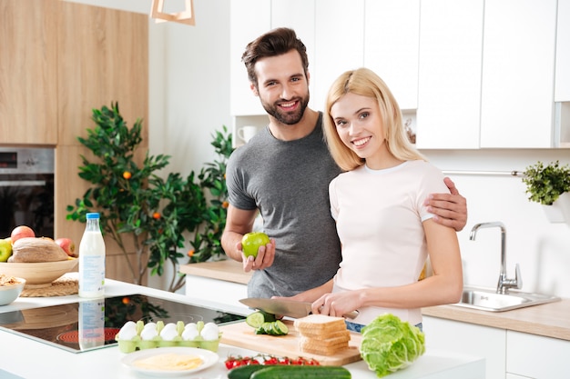 Encantadora pareja abrazándose en su cocina