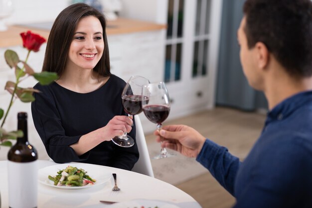 Encantadora pareja animando con copas de vino