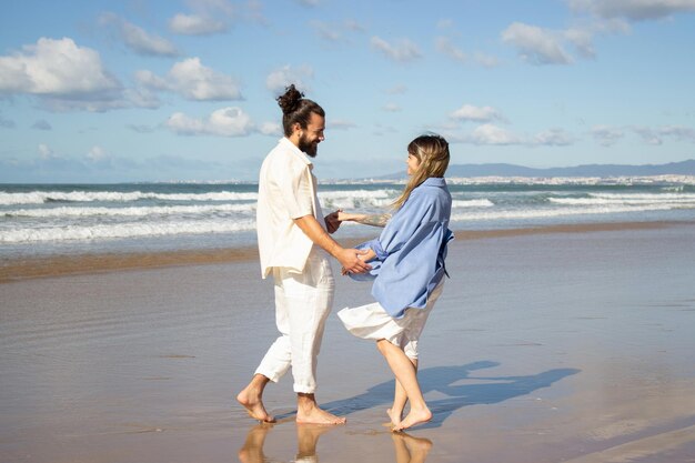 Encantadora pareja caucásica disfrutando de las vacaciones en la playa