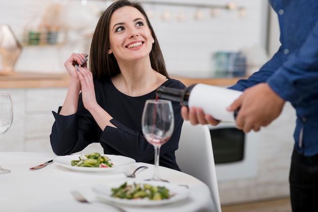 Encantadora pareja celebrando el día de San Valentín con una botella de vino