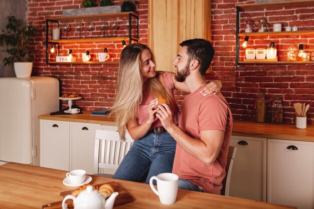 Encantadora pareja desayunando en la cocina