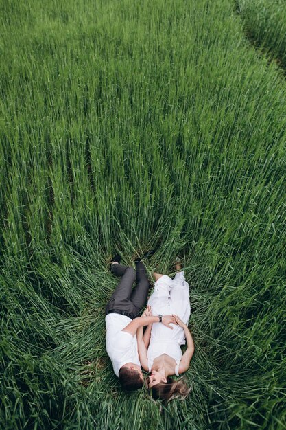 La encantadora pareja enamorada yace en el campo