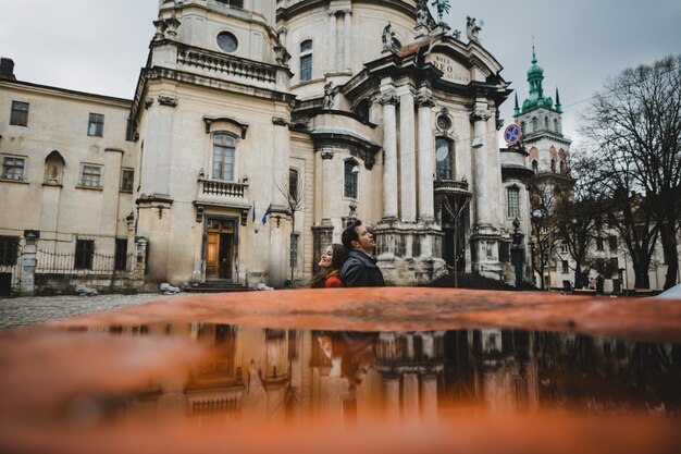 La encantadora pareja de enamorados abrazándose cerca de la catedral