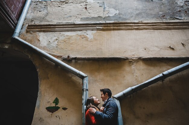 La encantadora pareja de enamorados abrazándose cerca del edificio