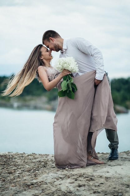 La encantadora pareja de enamorados abrazándose cerca del río