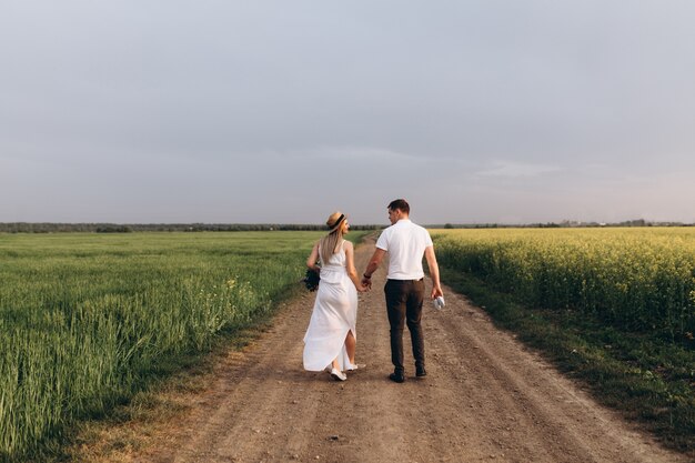 La encantadora pareja de enamorados caminando por el campo