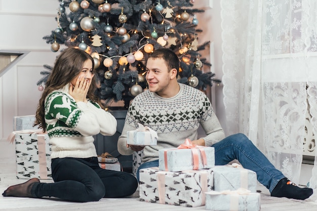 La encantadora pareja de enamorados mirando regalos