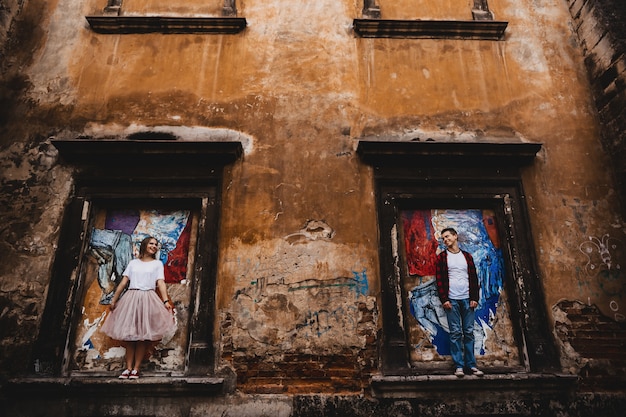 Foto gratuita la encantadora pareja de enamorados de pie en las ventanas