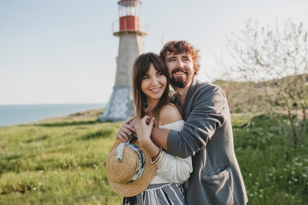 Encantadora pareja feliz abrazando hipster con estilo joven enamorado caminando en el campo