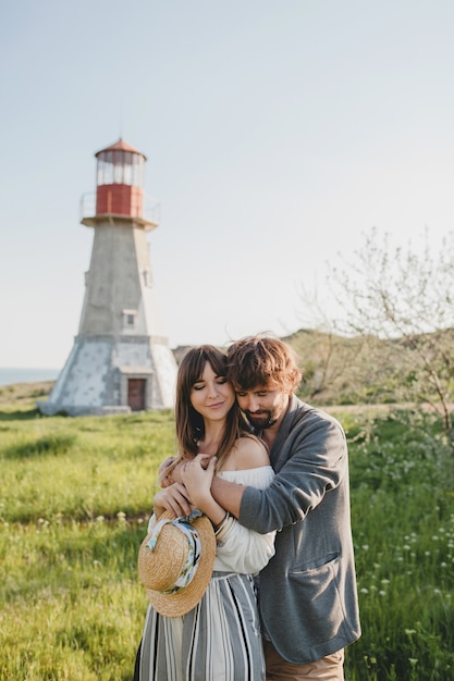 Encantadora pareja feliz abrazando hipster con estilo joven enamorado caminando en el campo