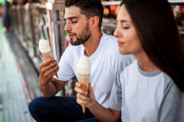 Encantadora pareja con helados en la feria