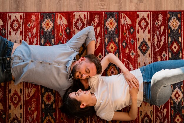 Encantadora pareja de jóvenes amantes hermosos en la alfombra