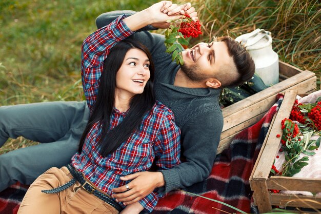 Encantadora pareja de jóvenes divirtiéndose en la hierba