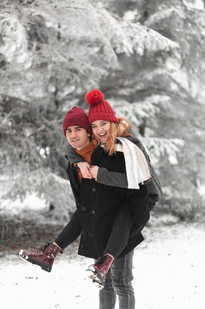 Encantadora pareja jugando afuera en el invierno