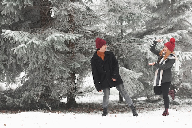 Foto gratuita encantadora pareja jugando con tiro largo de nieve