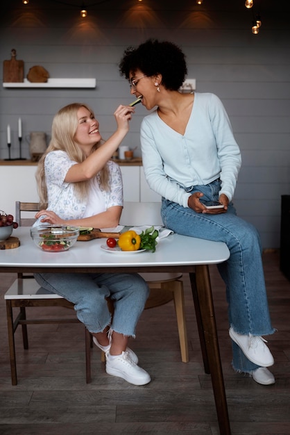 Encantadora pareja de lesbianas pasar tiempo juntos en la cocina