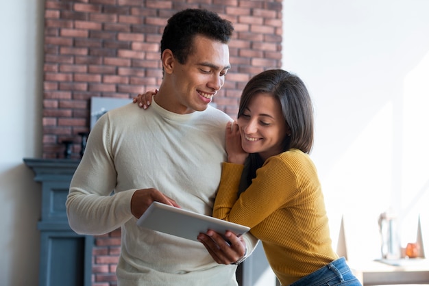 Foto gratuita encantadora pareja mirando tablet