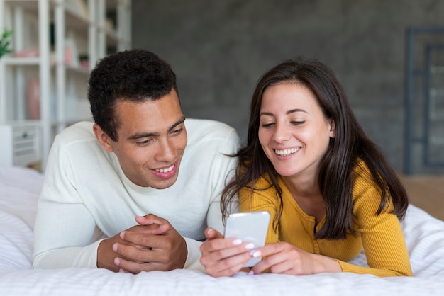 Foto gratuita encantadora pareja mirando el teléfono