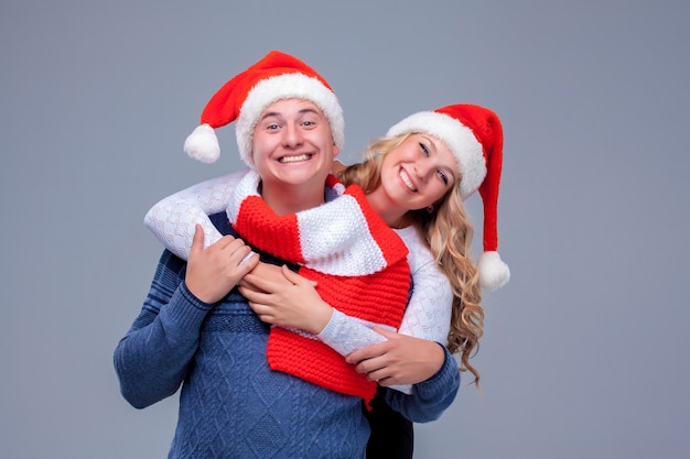 Encantadora pareja de Navidad con sombreros de Santa Claus