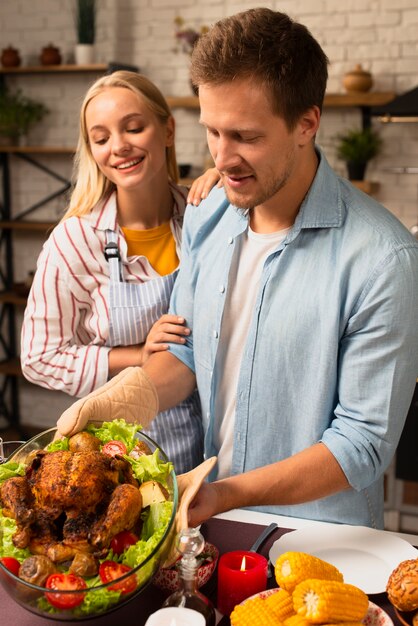 Encantadora pareja preparando el pavo de acción de gracias