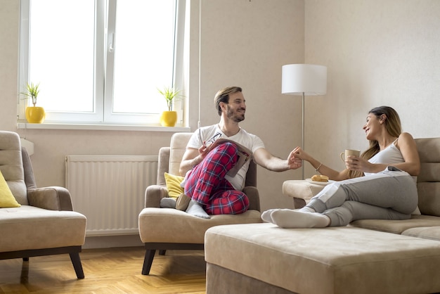 Encantadora pareja romántica tomando café y teniendo una agradable conversación en casa