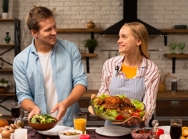 Encantadora pareja sosteniendo la comida y mirándose