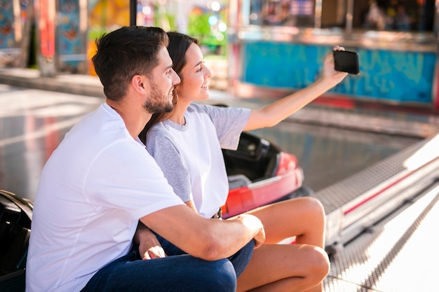 Encantadora pareja tomando selfie en feria