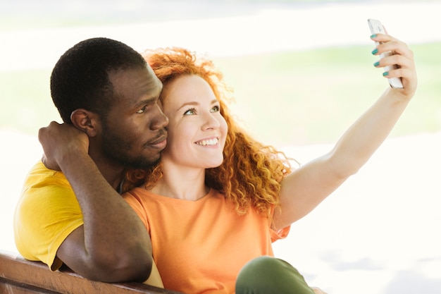 Foto gratuita encantadora pareja tomando un selfie en el parque