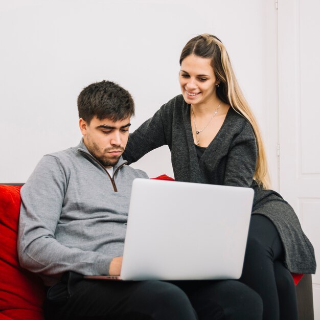 Encantadora pareja usando laptop