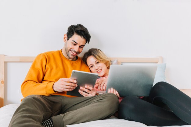 Encantadora pareja usando tecnologías