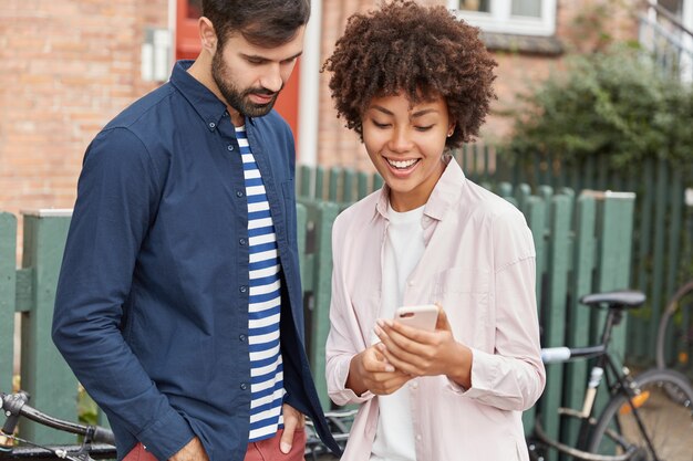 Encantadora pareja ver video en gadget afuera