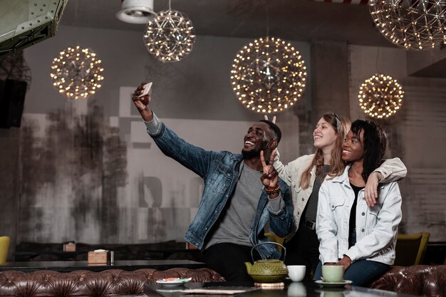 Encantadoras amigas multiculturales tomando una selfie