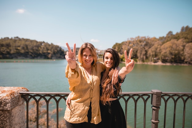 Encantadoras mujeres gesticulando la paz