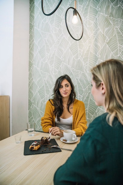 Encantadoras mujeres hablando en café