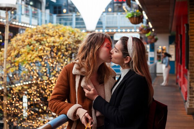 Encantadoras mujeres lesbianas besándose al aire libre