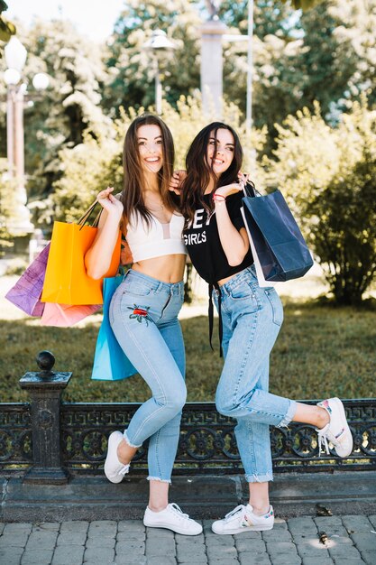 Encantadores modelos posando con bolsas de compras