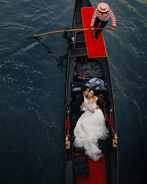 Encantadores recién casados tienen un paseo por el canal en la góndola de lujo en Venecia