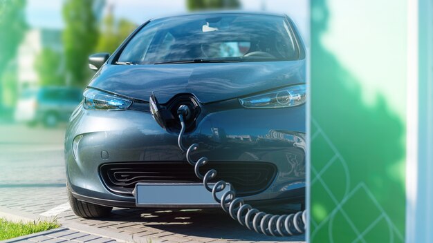 Enchufado el cargador a un coche eléctrico en la estación de carga