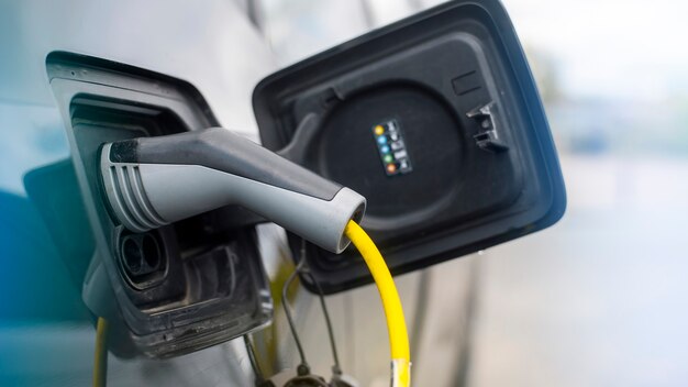 Enchufado el cargador a un coche eléctrico en la estación de carga