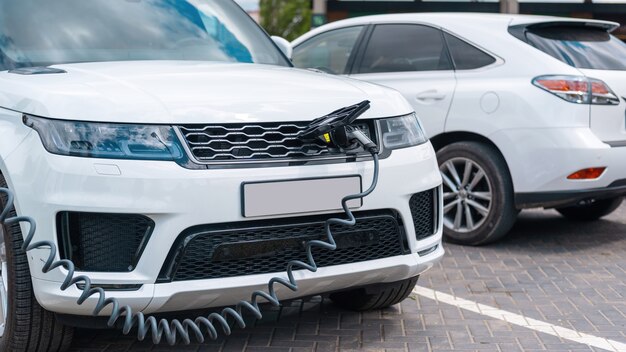 Enchufado el cargador a un coche eléctrico en la estación de carga