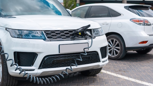 Enchufado el cargador a un coche eléctrico en la estación de carga