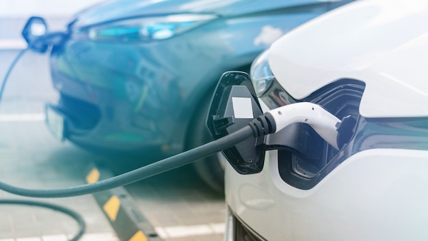 Enchufado cargadores en dos autos eléctricos en la estación de carga