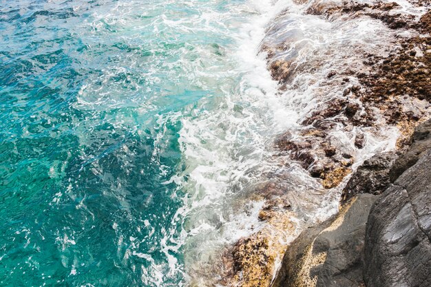 Por encima de las olas de vista en la costa rocosa