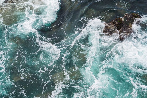 Por encima de la vista de agua ondulada en la costa rocosa