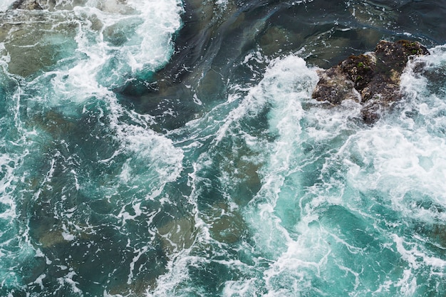 Por encima de la vista de agua ondulada en la costa rocosa