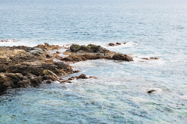 Por encima de la vista de agua ondulada en la costa rocosa