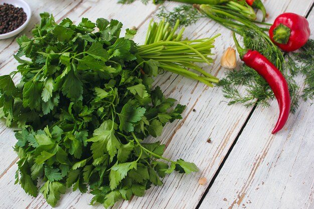 Encurtidos en mesa de madera blanca con pimientos verdes y rojos y ají, hinojo, sal, pimienta negra, ajo, guisantes, primer plano, concepto saludable, vista superior, endecha plana